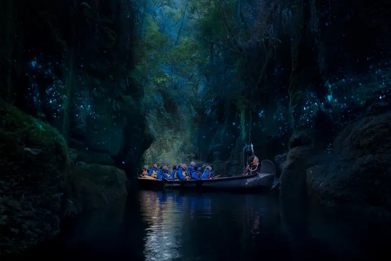 Group aboard the Big Kanu gliding through the glowworm canyon, Lake McLaren