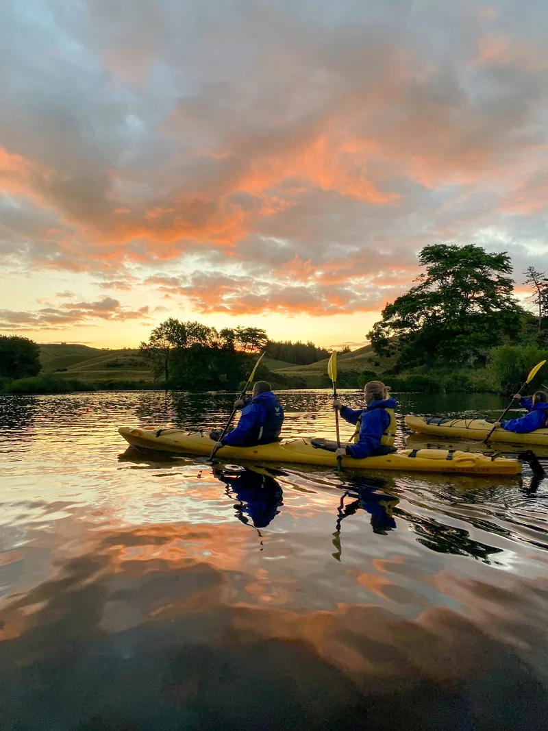 Two kayaks on mirror calm water at sunset