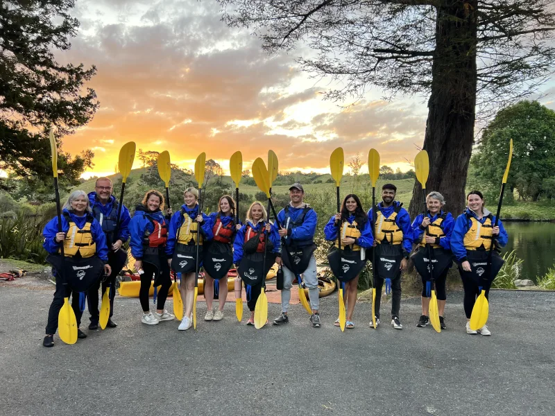 A private group, paddles up, at golden hour