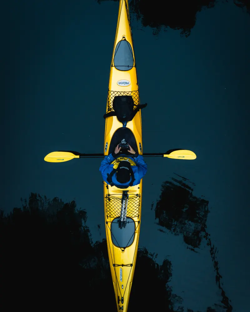 Overhead view of a yellow kayak on the still dark waters of Lake McLaren, Bay of Plenty