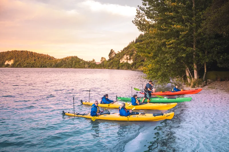 Kayakers gathering on the shore of Lake Rotoiti as evening falls