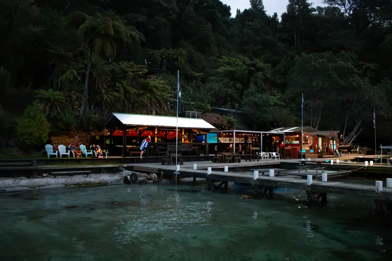 The lakeside lodge glowing at dusk on the Starlight Gourmet Kayak Tour