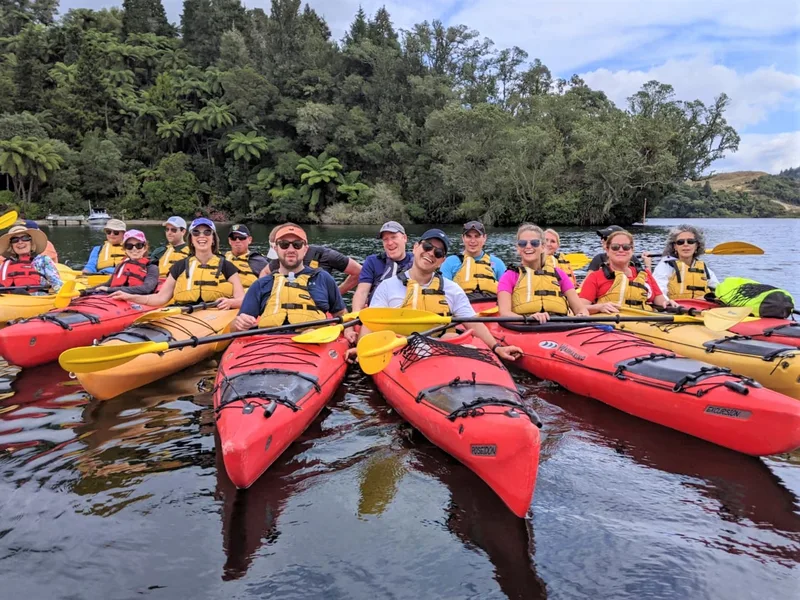 A team rafted up in red kayaks