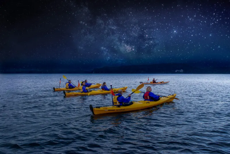 Kayakers under a starlit sky on Lake Rotoiti, Rotorua